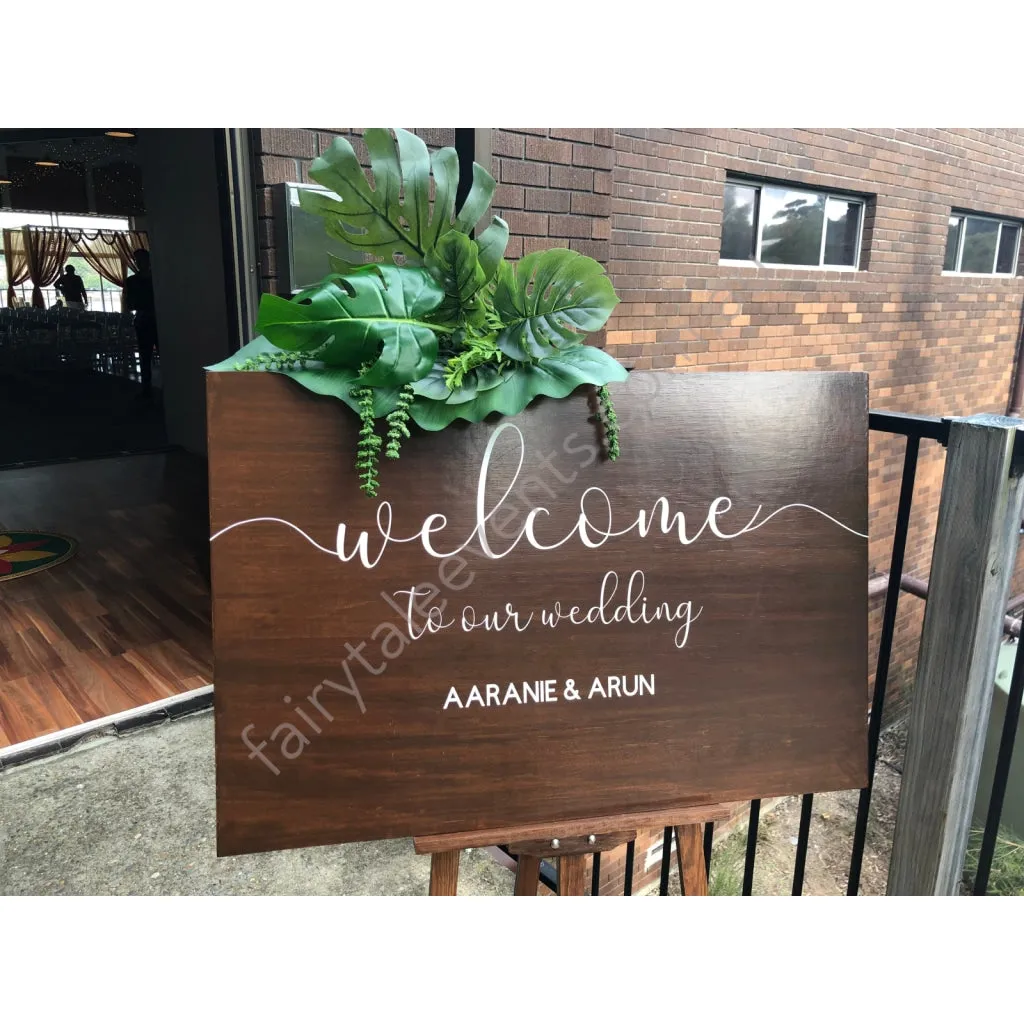 Rustic wooden sign with tropical leaf on white easel